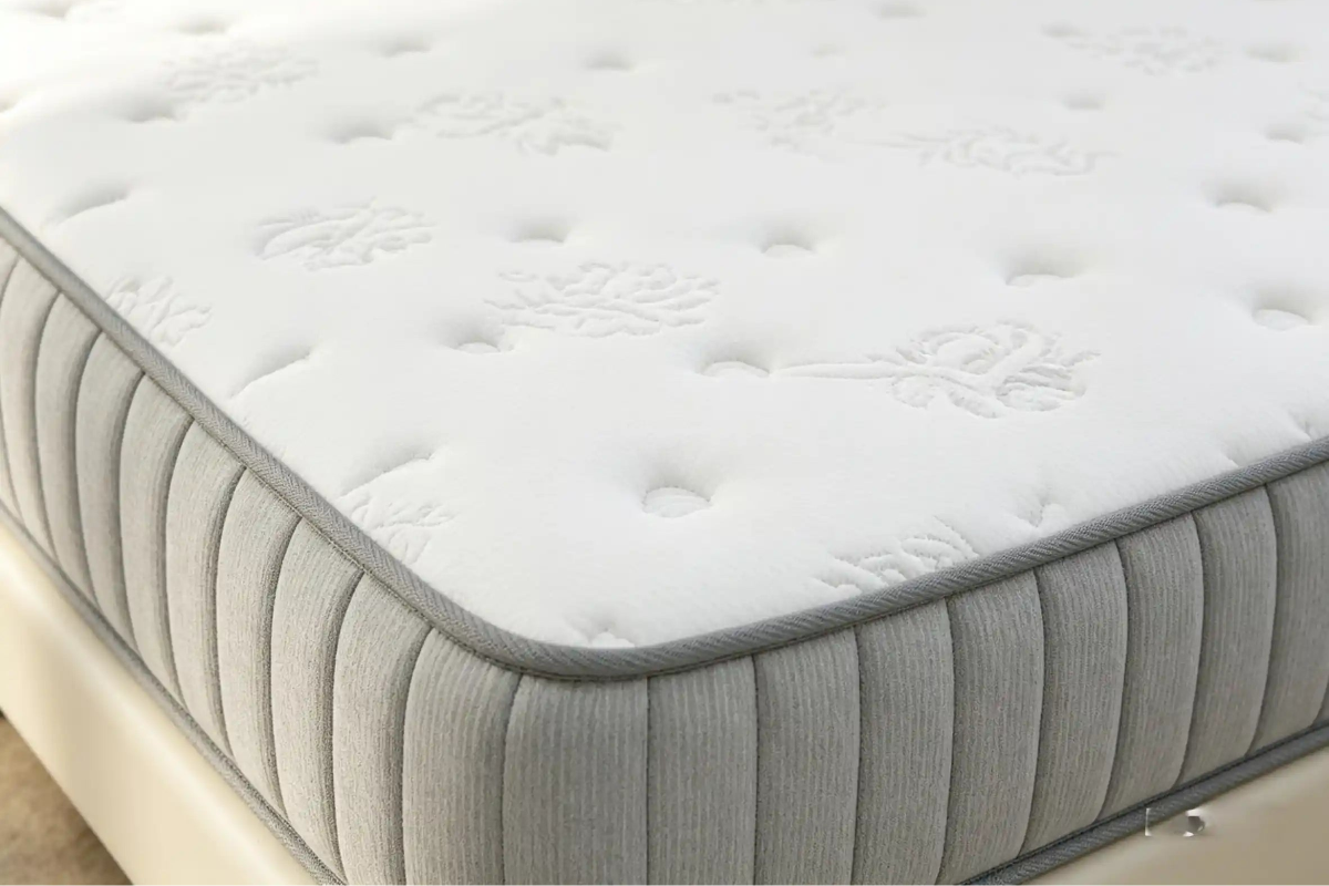 Gray and white mattress with brand logo on a plain background